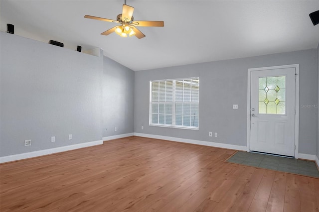 foyer entrance featuring wood finished floors, baseboards, vaulted ceiling, and ceiling fan