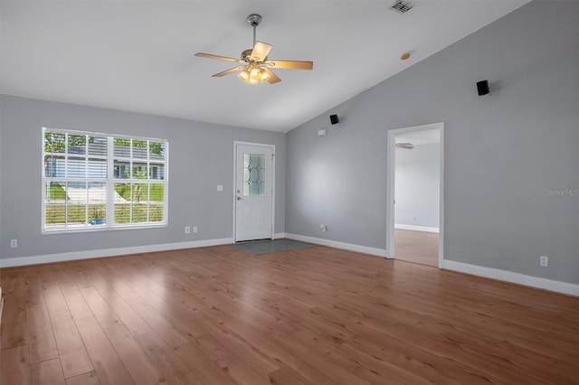 unfurnished living room featuring vaulted ceiling, ceiling fan, wood finished floors, and baseboards