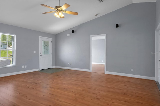 unfurnished living room with vaulted ceiling, light wood finished floors, a ceiling fan, and baseboards