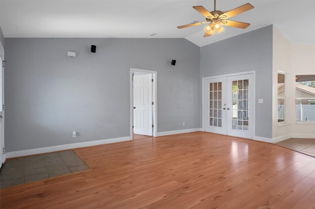 spare room featuring high vaulted ceiling, french doors, light wood finished floors, a ceiling fan, and baseboards