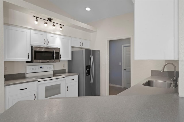 kitchen featuring stainless steel appliances, a sink, and white cabinets
