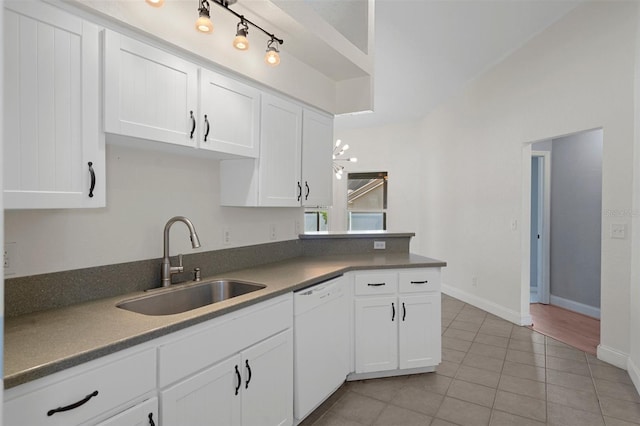 kitchen featuring dishwasher, a sink, white cabinets, and light tile patterned floors