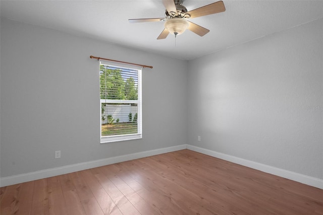 unfurnished room featuring wood finished floors, baseboards, and ceiling fan