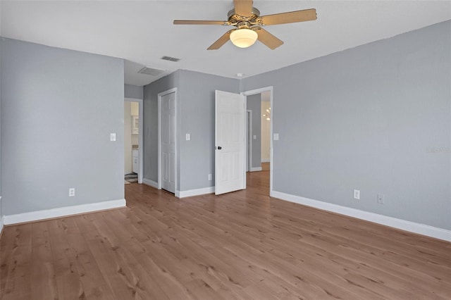 empty room featuring ceiling fan, light wood-style flooring, and baseboards