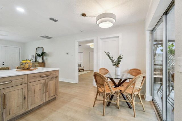 dining area with light wood finished floors and baseboards