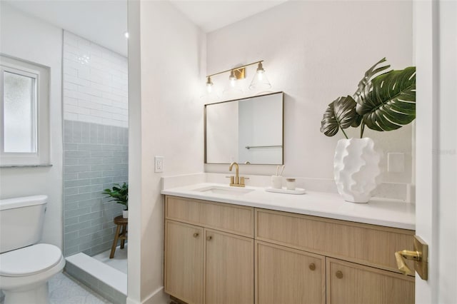 bathroom featuring toilet, vanity, and tiled shower