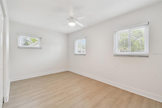 empty room with plenty of natural light, a ceiling fan, and baseboards