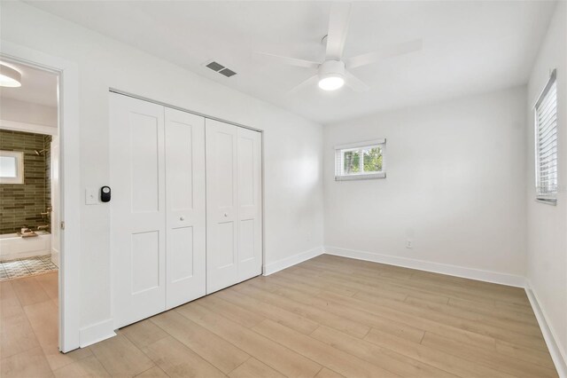 unfurnished bedroom with light wood-style floors, a closet, baseboards, and ceiling fan