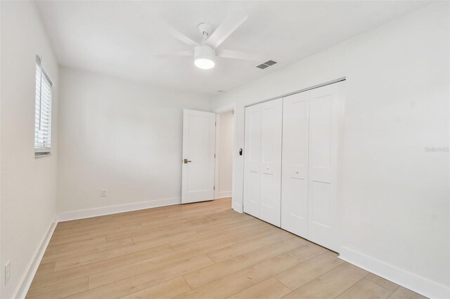unfurnished bedroom with light wood-type flooring, baseboards, a closet, and ceiling fan