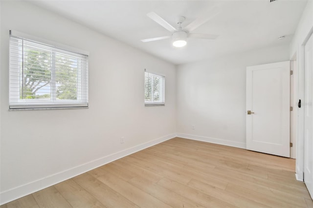 empty room featuring baseboards, light wood-type flooring, and a ceiling fan