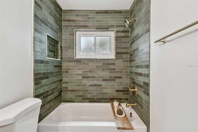 bathroom with washtub / shower combination and toilet
