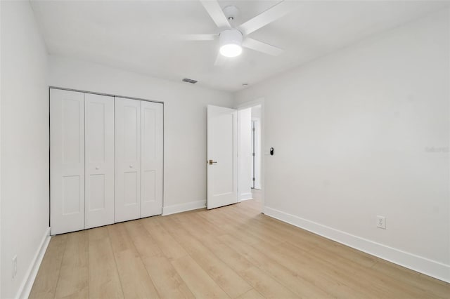 unfurnished bedroom with baseboards, light wood finished floors, a closet, and ceiling fan