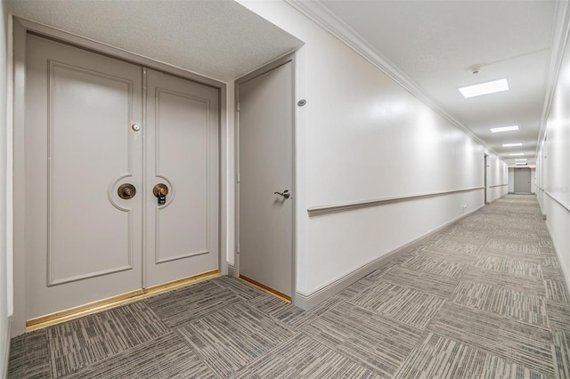 corridor with carpet, crown molding, and baseboards