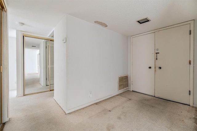 empty room featuring carpet flooring and a textured ceiling