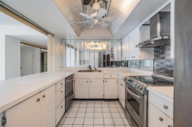 kitchen with appliances with stainless steel finishes, a sink, wall chimney range hood, light countertops, and a ceiling fan
