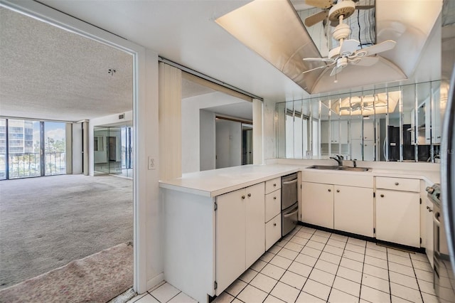 kitchen with a sink, appliances with stainless steel finishes, a ceiling fan, light countertops, and open floor plan