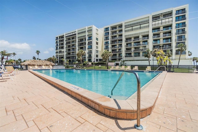 community pool featuring fence and a patio