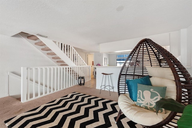 745 Pinellas Bayway S Unit 206, Saint Petersburg, FL 33715 - sitting room with carpet flooring, a textured ceiling, and an upstairs landing
