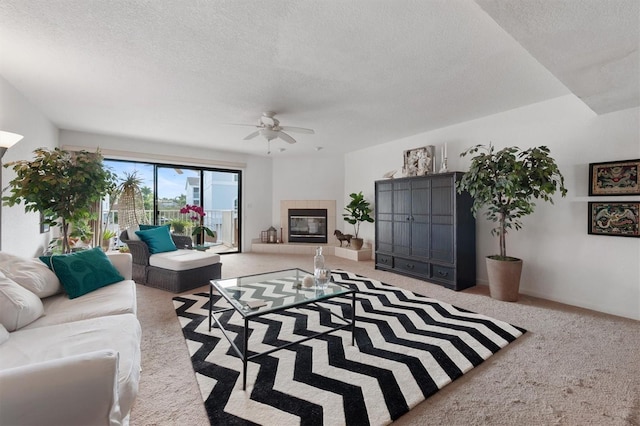 745 Pinellas Bayway S Unit 206, Saint Petersburg, FL 33715 - carpeted living room featuring a textured ceiling, ceiling fan, and a tiled fireplace
