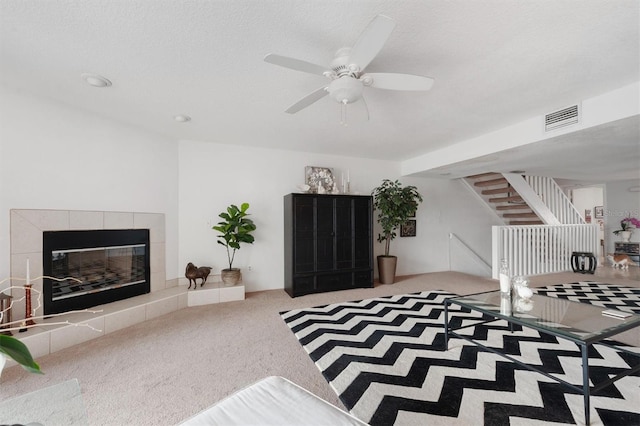 745 Pinellas Bayway S Unit 206, Saint Petersburg, FL 33715 - carpeted living area featuring a tile fireplace, ceiling fan, and stairs