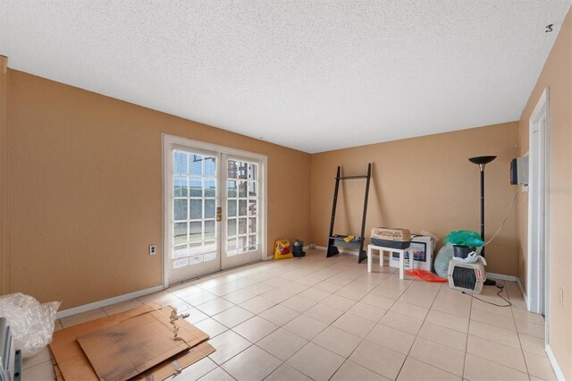 745 Pinellas Bayway S Unit 206, Saint Petersburg, FL 33715 - recreation room featuring a textured ceiling, french doors, baseboards, and light tile patterned floors