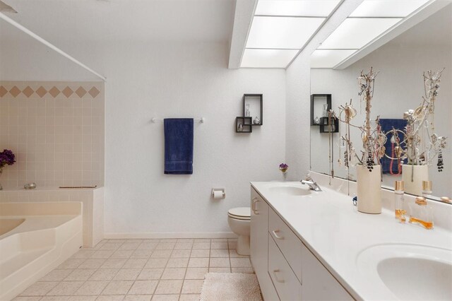 745 Pinellas Bayway S Unit 206, Saint Petersburg, FL 33715 - bathroom with a garden tub, baseboards, tile patterned flooring, toilet, and double vanity