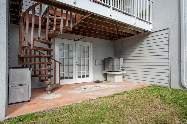 745 Pinellas Bayway S Unit 206, Saint Petersburg, FL 33715 - property entrance with french doors, a balcony, stucco siding, and central AC unit