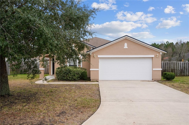 view of front of house featuring an attached garage, stucco siding, driveway, and fence
