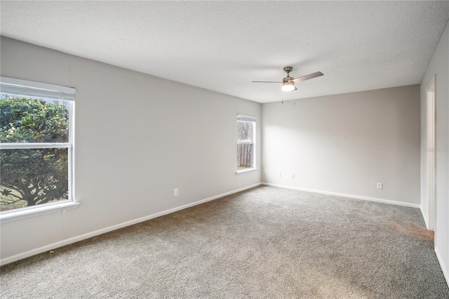 empty room featuring a textured ceiling, baseboards, ceiling fan, and carpet floors