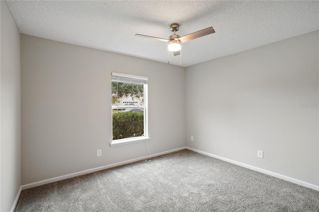carpeted empty room with a textured ceiling, baseboards, and a ceiling fan