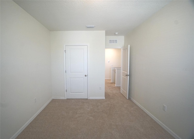 10928 Carlton Fields Dr, Riverview, FL 33579 - unfurnished bedroom featuring light colored carpet, a textured ceiling, visible vents, and baseboards