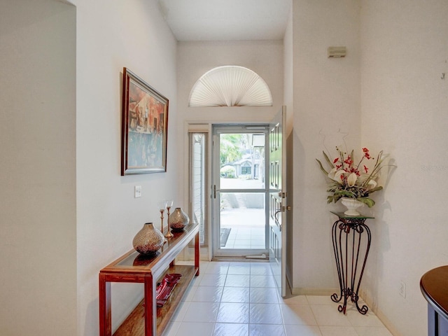 doorway to outside with light tile patterned floors and baseboards