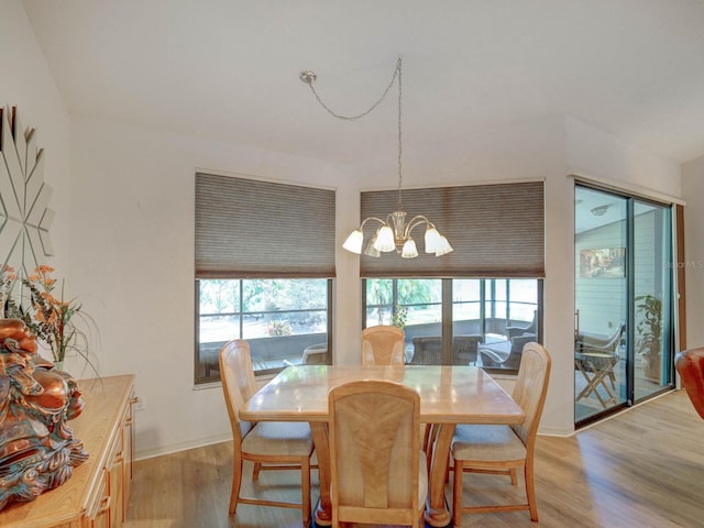 dining room with light wood-style floors, a chandelier, and baseboards