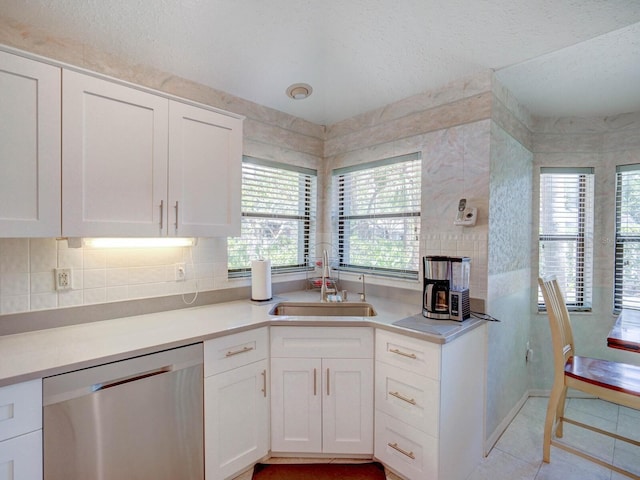 kitchen featuring dishwasher, a sink, white cabinets, a textured ceiling, and light countertops