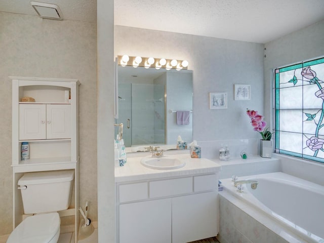 full bathroom with toilet, vanity, a garden tub, and a textured ceiling