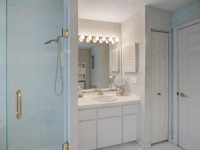 bathroom with a stall shower, vanity, a closet, and tile patterned floors