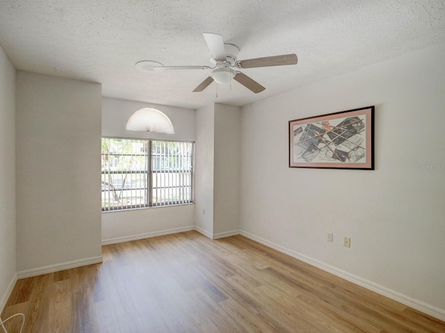 unfurnished room with wood finished floors, a textured ceiling, ceiling fan, and baseboards