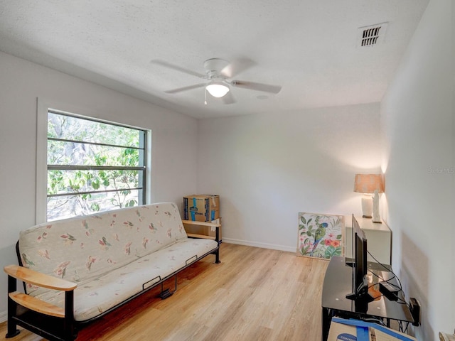 sitting room with ceiling fan, light wood-style floors, and baseboards
