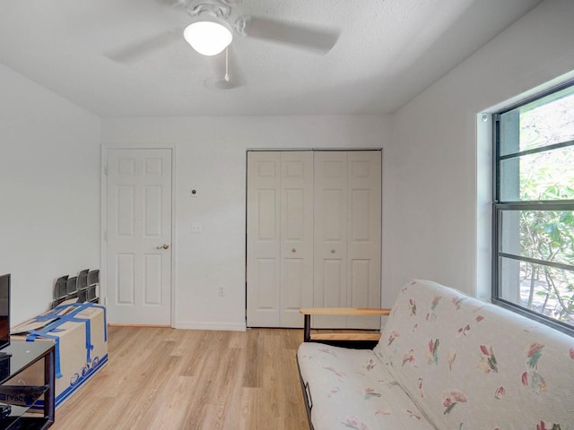living area with light wood-style flooring and ceiling fan