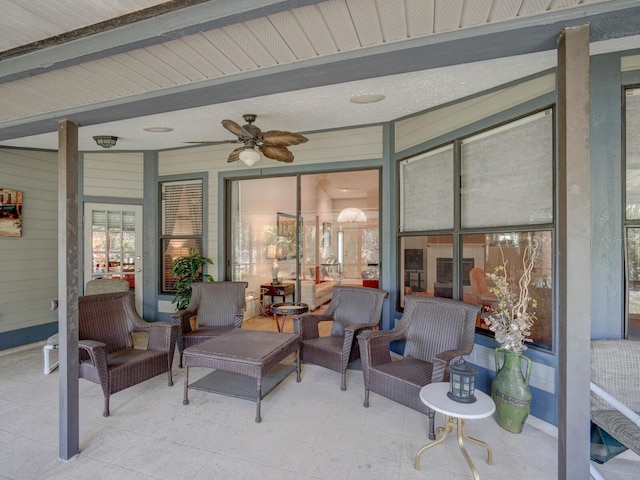 sunroom / solarium with beam ceiling and a ceiling fan