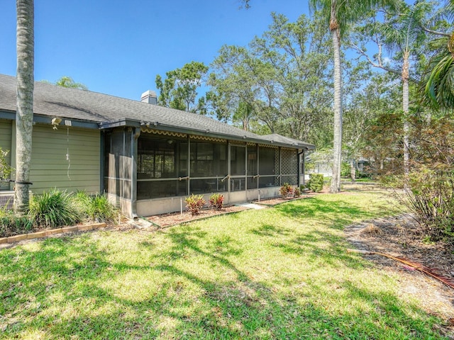 view of grassy yard featuring a sunroom