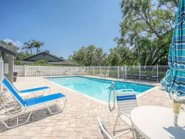 community pool featuring fence and a patio area