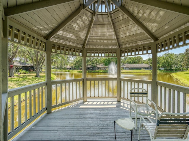 deck featuring a water view, a gazebo, and view of wooded area