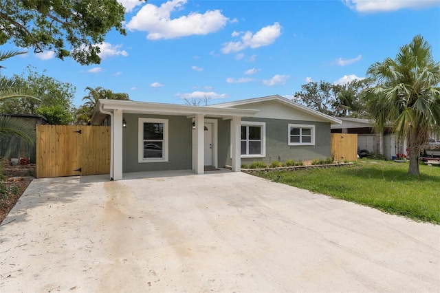 ranch-style home featuring a gate and stucco siding