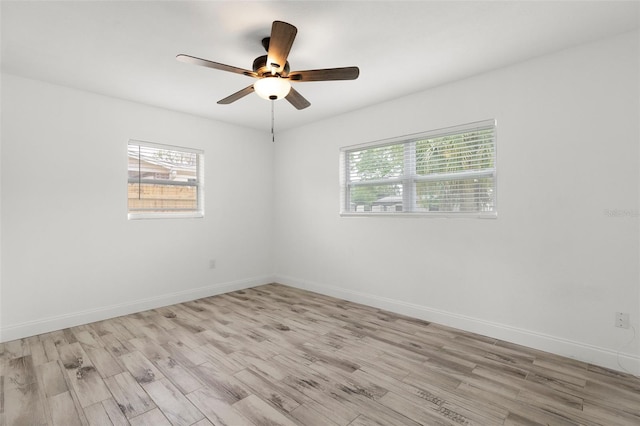 empty room with plenty of natural light, light wood-style floors, and a ceiling fan