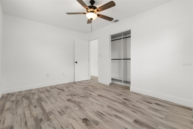 unfurnished bedroom featuring light wood-style flooring, baseboards, a ceiling fan, and a closet