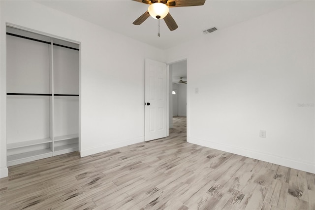 unfurnished bedroom featuring light wood finished floors, a closet, a ceiling fan, and baseboards