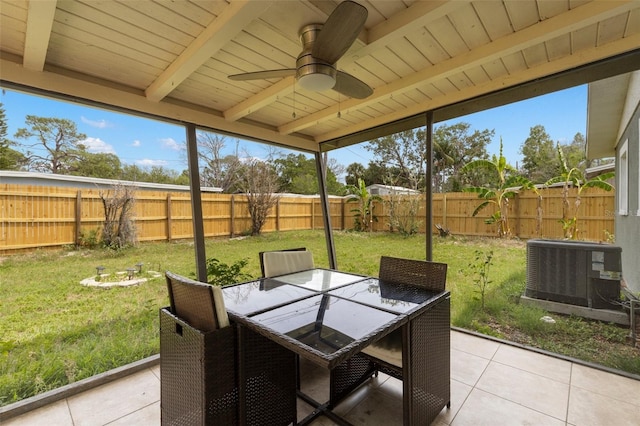 sunroom featuring beam ceiling, a ceiling fan, outdoor dining space, and healthy amount of natural light