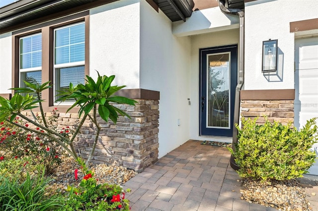 property entrance with stone siding and stucco siding