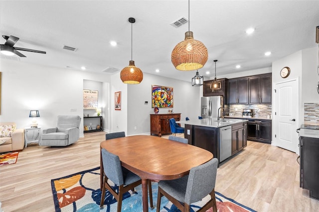 dining space with light wood finished floors, recessed lighting, a ceiling fan, and baseboards